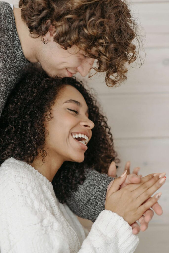 A happy interracial couple smiling and holding hands. You can have a happy and successful intercultural relationship with the help of multicultural counseling in South Bay, CA. Learn how multicultural couples therapy can help you and your partner work through cultural differences and find common ground.